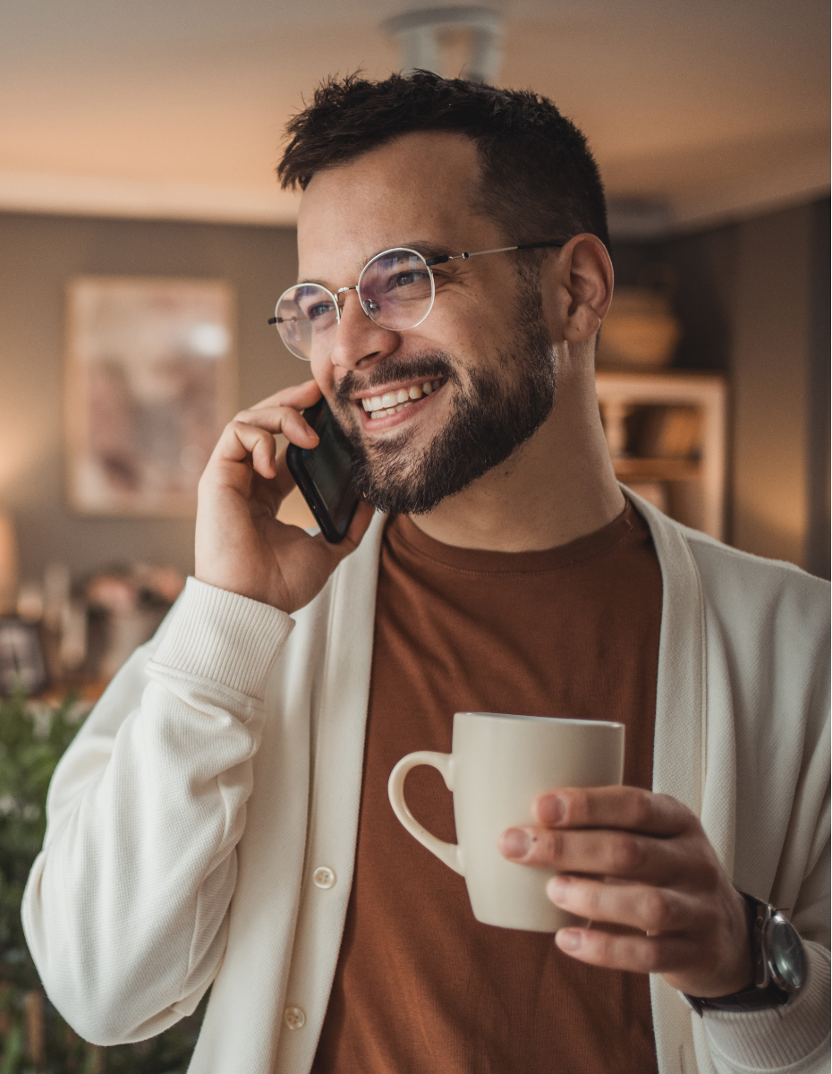 Mann beim Telefonieren mit Kaffeetasse.
